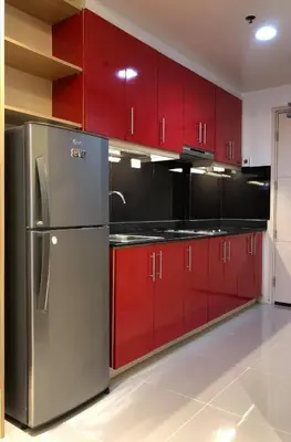 a kitchen with red cabinets and a stainless steel refrigerator at Sea Residence in Manila