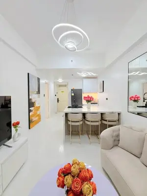 a living room with a couch and a table with flowers at Le Luxe 102 by Ara li in Manila