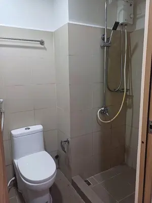 a bathroom with a toilet and a shower at Cozy and Comfortable 1BedRoom at Coast Residences in Manila