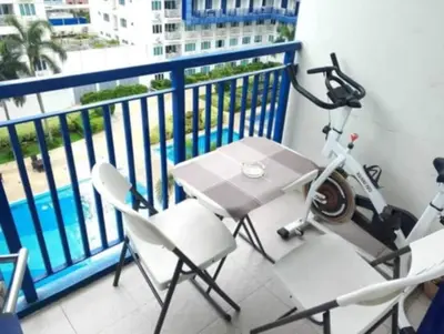 a balcony with a bike and a table and chairs at Ederly Place at Sea Residences near Moa in Manila