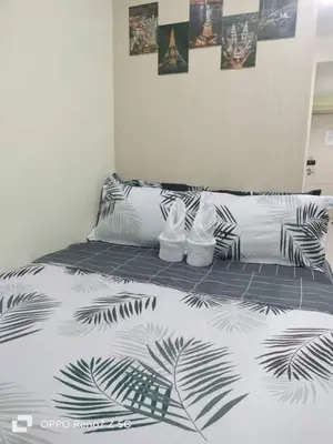 a bed with a black and white comforter with shoes on it at Ederly Place at Sea Residences near Moa in Manila