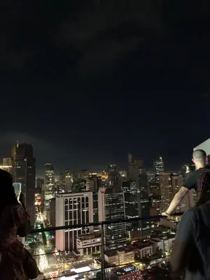 a man standing on a ledge overlooking a city at night at All Access Manila Tour in Manila