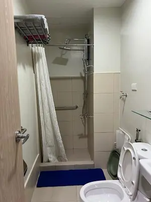 a bathroom with a shower and a toilet at 1BR luxury bed, movie room, swimming pool access in Manila
