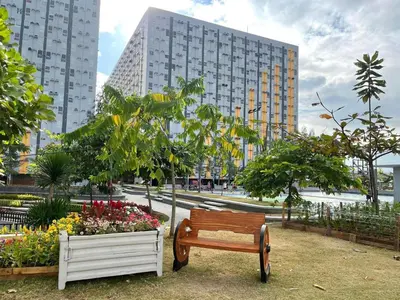 a park with a bench and flowers and buildings at Affordable Fully Furnished Place in the City in Manila