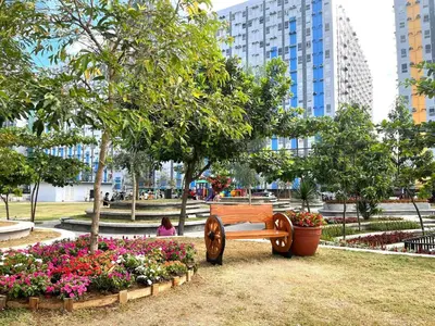 a park with a bench and flowers and buildings at Affordable Fully Furnished Place in the City in Manila