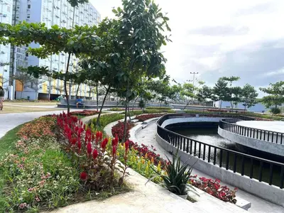 a garden with flowers and a pond in a city at Affordable Fully Furnished Place in the City in Manila