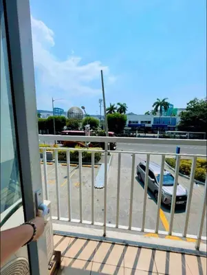a person standing on a balcony looking at a parking lot at Shell Residence Tower A 250A in Manila