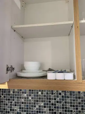 a shelf with a stack of plates and bowls at Shell Residence Tower A 250A in Manila