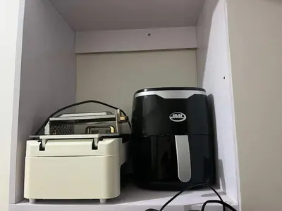 a coffee maker and toaster sitting on a shelf at 2BR Family suite with Balcony with WiFi and Netflix, behind SM Sucat in Manila