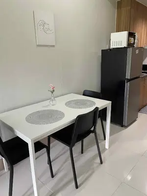 a white table and chairs in a kitchen with a refrigerator at 10 minutes from MOA - Cozy Condo with Hot Shower & Balcony in Manila