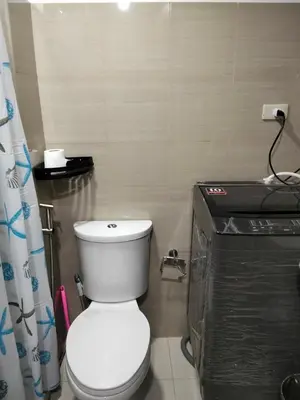a bathroom with a white toilet in a room at VSV Luxury Family Suite staycation Moa in Manila