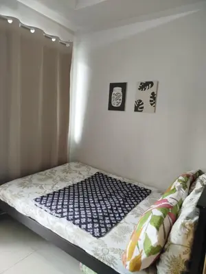 a bed in a room with some pictures on the wall at Dash Shell Residences in Manila