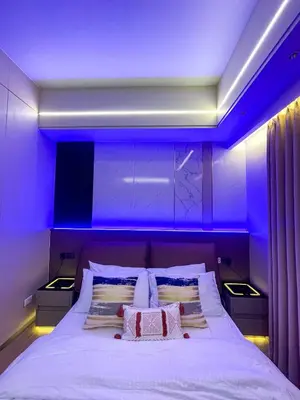 a bedroom with a bed with purple lighting at Bayshore 9g 4br in Manila