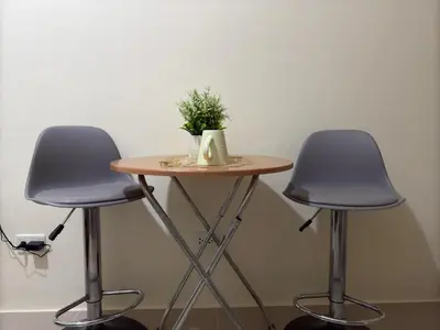 a small table with two chairs and a plant on it at Condo in Cubao by Cindy in Manila