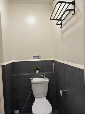 a bathroom with a toilet with a plant on the wall at Condo in Cubao by Cindy in Manila