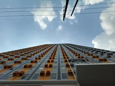 a tall building with chairs on the side of it at Condo in Cubao by Cindy in Manila