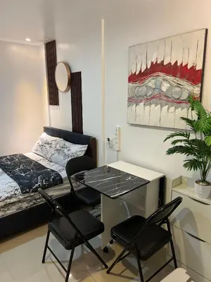 a room with a bed and a table and chairs at Cozy Studio near MOA, Airport & Star City, Pasay in Manila