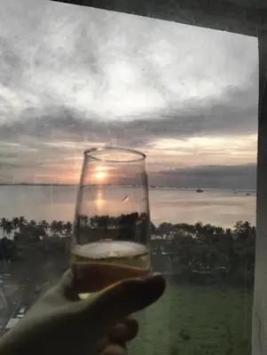 a hand holding a glass of wine in front of a window at Chic Haven in Manila