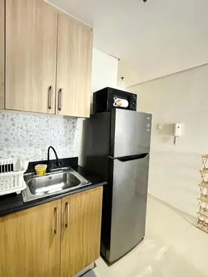 a kitchen with a stainless steel refrigerator and a sink at Shore Residences 2 Bedroom with Balcony Near NAIA Airport MOA in Manila