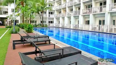 a swimming pool in a building with benches next to it at Shore Residences 2 Bedroom with Balcony Near NAIA Airport MOA in Manila