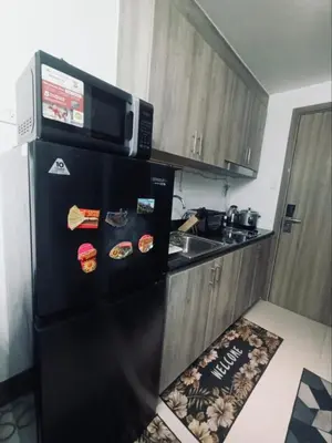 a black refrigerator in a kitchen with a microwave at Casa Arville in Manila