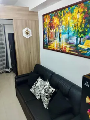 a living room with a couch and a painting on the wall at Casa Arville in Manila