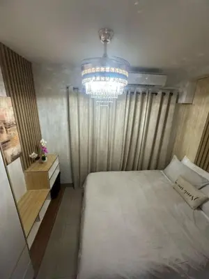 a bedroom with a large bed and a chandelier at Shore 2 Residence Homes Near MOA in Manila