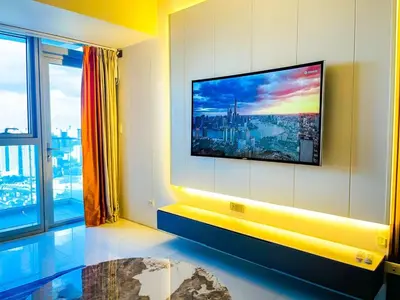 a living room with a flat screen tv on a wall at Luxury 2BR Penthouse Across Uptown BGC I Modern in Manila
