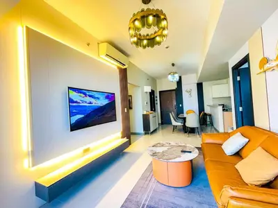 a living room with a couch and a tv on a wall at Luxury 2BR Penthouse Across Uptown BGC I Modern in Manila