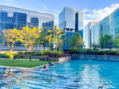 people floating in a pool in a city with tall buildings at Ultra-Luxury 3BR Penthouse in Uptown BGC in Manila