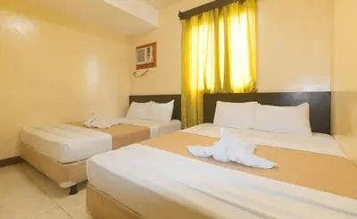 two beds in a hotel room with towels on them at J and T Jamich Suites by RedDoorz in Manila