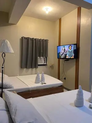 a bedroom with two beds and a flat screen tv at P3k suites barkada family room in Manila