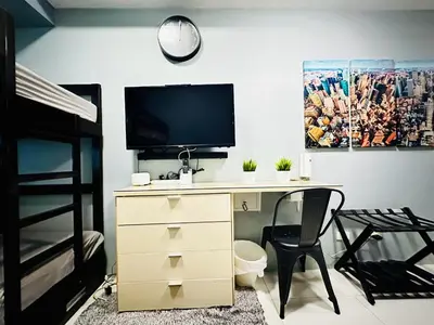 a bedroom with a desk with a television and a bunk bed at STYLISH LUXE APARTMENT in SMDC GREEN RESIDENCES in Manila