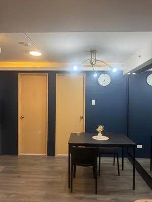 a room with a table and chairs and clocks on the wall at 2BR Apartment in Pasig City in Manila