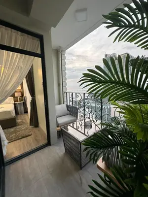 a room with a balcony with a view of the ocean at La nobleza terrazas 2 bedroom condominium in Manila