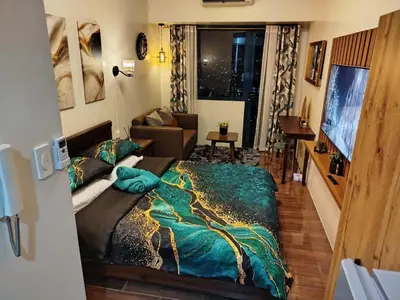 a bedroom with a bed and a couch at Modern-Studio with Balcony Stunning View in Manila
