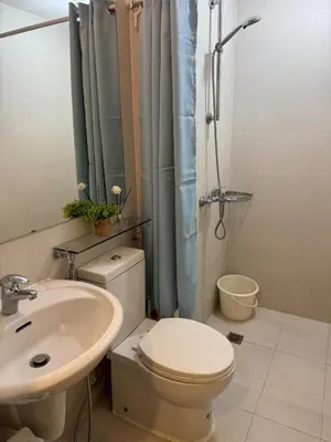 a bathroom with a toilet and a sink and a shower at A&J azure getaway in Manila