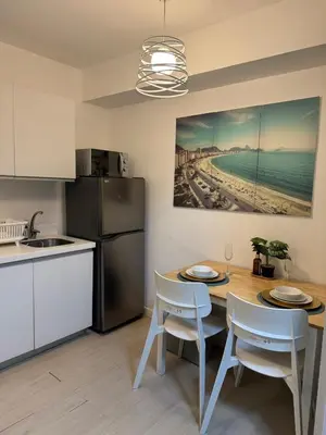 a kitchen with a table with chairs and a refrigerator at A&J azure getaway in Manila