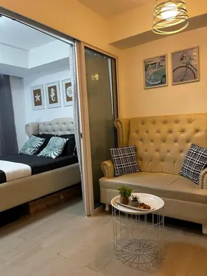 a living room with a couch and a bed at A&J azure getaway in Manila