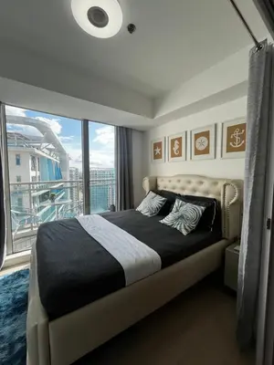 a bedroom with a bed and a large window at A&J azure getaway in Manila