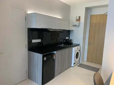 a kitchen with a stove and a washer and dryer at Diamond Studio in Manila
