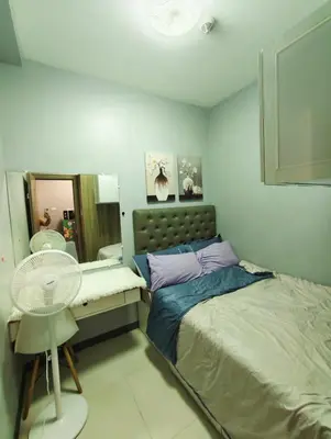 a bedroom with a bed and a desk and a fan at Experience Unforgettable Moments in Manila
