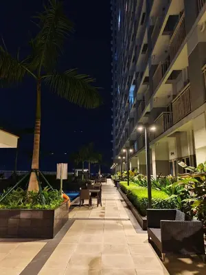 a walkway with chairs and a palm tree in a building at Experience Unforgettable Moments in Manila