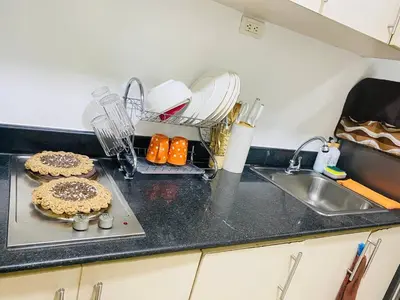 a kitchen counter top with a pie on a cutting board at Sea Residence By Kenshin Staycation in Manila