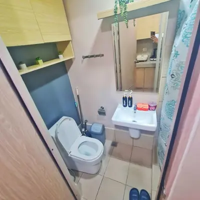 a small bathroom with a toilet and a sink at HOMELY Green 2 Residences near DLSUHSI in Dasmariñas