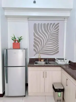 a kitchen with a white refrigerator and a sink at Tan condo fairway in Manila