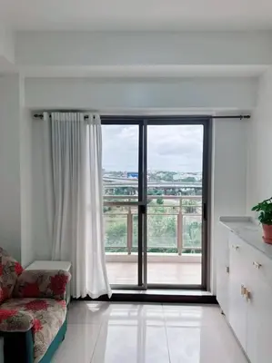 a living room with a large window and a couch at Tan condo fairway in Manila