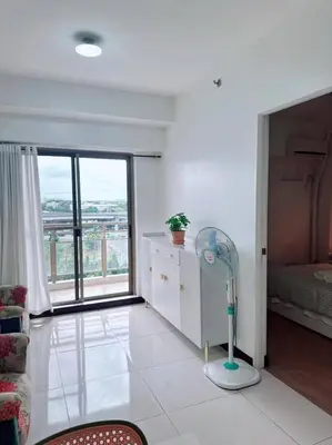 a living room with a floor fan and a bedroom at Tan condo fairway in Manila