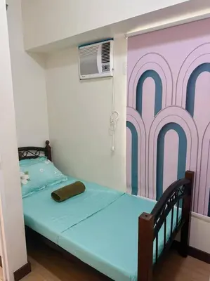 a bedroom with a bed with a painting on the wall at Tan condo city view 01 in Manila