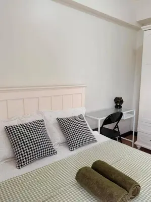 a bed with two pillows and a green towel on it at Tan condo city view 01 in Manila